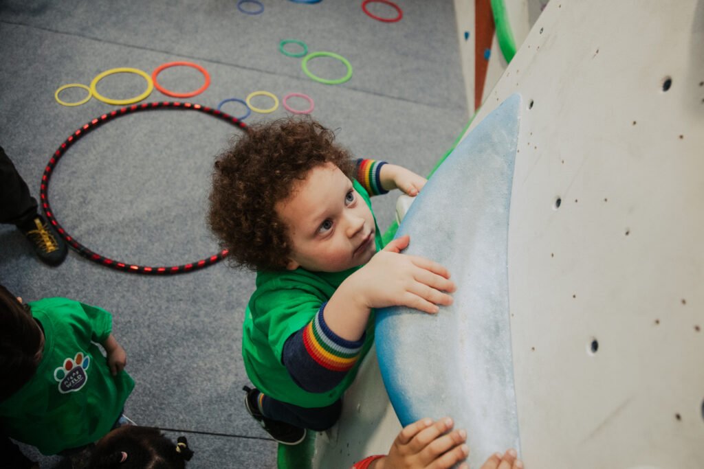 Young climber in green tshirt taking part in Wild Climbers games